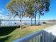 Picturesque view from a porch overlooking a pristine lake with docks, benches, and mature shade trees at 11001 Se Sunset Harbor Rd # A08, Summerfield, FL 34491