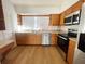 Efficient kitchen with stainless steel appliances, light countertops, and matching oak cabinets at 11001 Se Sunset Harbor Rd # A08, Summerfield, FL 34491