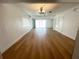 Bright, open living room featuring sleek hardwood floors and ample natural light from large sliding glass doors at 11001 Se Sunset Harbor Rd # A08, Summerfield, FL 34491