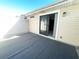 A sunny outdoor patio with a sliding glass door entrance to the home at 11001 Se Sunset Harbor Rd # A08, Summerfield, FL 34491