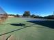 A view of a tennis court in a well-maintained community with a clean surface and clear skies at 11001 Se Sunset Harbor Rd # A08, Summerfield, FL 34491