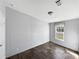 A bright bedroom has wood-look flooring, a neutral-toned wall, and a window with a view at 11745 Nw 15Th Lane, Ocala, FL 34482