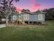 Charming single-story home with blue siding, landscaped yard, and cozy front porch at 11745 Nw 15Th Lane, Ocala, FL 34482