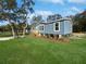 Charming single-story home with blue siding, landscaped yard, and cozy front porch at 11745 Nw 15Th Lane, Ocala, FL 34482