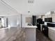 A modern kitchen with an island, neutral cabinets, black appliances, and light wood floor at 11745 Nw 15Th Lane, Ocala, FL 34482