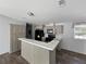 A modern kitchen with an island, neutral cabinets, black appliances, a large pantry, and wood floor at 11745 Nw 15Th Lane, Ocala, FL 34482