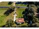 Aerial view of a rural property featuring a charming home with a red roof on a green lawn at 1255 Ne 70Th St, Ocala, FL 34479