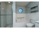 Bathroom features a tub and shower, a sink vanity, decorative circular window and tile accents at 1255 Ne 70Th St, Ocala, FL 34479