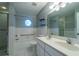Bathroom features a tub and shower, a sink vanity, decorative circular window and tile accents at 1255 Ne 70Th St, Ocala, FL 34479