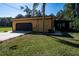 Exterior home elevation featuring a two car garage with a large paved driveway and grass lawn at 1255 Ne 70Th St, Ocala, FL 34479