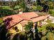 Aerial view of a one-story home with a vibrant orange roof and lush green landscaping at 1255 Ne 70Th St, Ocala, FL 34479