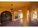 Arched front porch with red tile flooring, columns, and a rustic wooden door at 1255 Ne 70Th St, Ocala, FL 34479