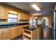 Spacious kitchen featuring a kitchen island, stainless steel appliances, dark countertops and wood cabinetry at 1255 Ne 70Th St, Ocala, FL 34479