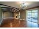 Bright living room featuring hardwood floors, exposed wood beams, and access to the screened in lanai at 1255 Ne 70Th St, Ocala, FL 34479