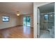 View of the living room with wood floor, ceiling fan, access to the back yard and an attached bathroom at 1255 Ne 70Th St, Ocala, FL 34479