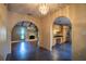 Open-concept living space with arched doorways, tile floors, and views into the adjacent kitchen and living room at 1255 Ne 70Th St, Ocala, FL 34479