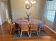 Comfortable dining room area with hardwood floors, bright window, and a chandelier at 12752 Se 91St Terrace Rd, Summerfield, FL 34491