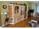 Well-lit living room with hardwood floors, a decorative cabinet, and comfortable furniture at 12752 Se 91St Terrace Rd, Summerfield, FL 34491