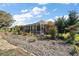 An outdoor screened-in lanai surrounded by manicured landscaping and lush greenery in the backyard at 13424 Se 89Th Terrace Rd, Summerfield, FL 34491