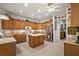 Well-lit kitchen with wood cabinets, island, and stainless steel refrigerator offers space and convenience at 13424 Se 89Th Terrace Rd, Summerfield, FL 34491