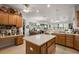 Spacious kitchen with wood cabinets, an island, and an adjacent breakfast nook offers ample space for Gathering meals at 13424 Se 89Th Terrace Rd, Summerfield, FL 34491