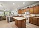 Open kitchen design featuring wood cabinets, white appliances, and an island creates a welcoming atmosphere at 13424 Se 89Th Terrace Rd, Summerfield, FL 34491