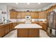 Bright kitchen features wood cabinets, stainless steel appliances, and an island, perfect for cooking and entertaining at 13424 Se 89Th Terrace Rd, Summerfield, FL 34491