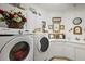 View of the laundry room featuring a large counter, front loading washer and dryer and lots of storage space at 13424 Se 89Th Terrace Rd, Summerfield, FL 34491