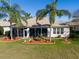 Inviting backyard showcasing a screened lanai, tropical palm trees, and colorful flowerbeds for serene outdoor living at 13544 Se 89Th Terrace Rd, Summerfield, FL 34491