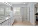 Bright bathroom featuring double vanity with granite countertop and separate tub and glass shower at 13544 Se 89Th Terrace Rd, Summerfield, FL 34491