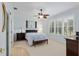 Bright bedroom with shutters, ceiling fan, carpet flooring, and a large window with natural light at 13544 Se 89Th Terrace Rd, Summerfield, FL 34491