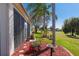 Exterior view of home featuring a screened lanai, lush landscaping, and a view of the golf course at 13544 Se 89Th Terrace Rd, Summerfield, FL 34491