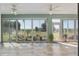 Bright sunroom featuring tile flooring, ceiling fans, and views of the landscaped golf course at 13544 Se 89Th Terrace Rd, Summerfield, FL 34491