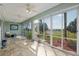 Large sunroom with ceiling fans, tile floors and sliding glass windows with golf course view at 13544 Se 89Th Terrace Rd, Summerfield, FL 34491