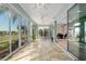 Spacious sunroom featuring tile flooring, multiple ceiling fans, and view of the golf course at 13544 Se 89Th Terrace Rd, Summerfield, FL 34491