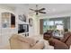 Cozy living room with tile floors, ceiling fan, media center, comfortable seating, and sliding glass doors at 13544 Se 89Th Terrace Rd, Summerfield, FL 34491