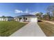 This single-story home boasts an expansive driveway, a one-car garage, and a verdant lawn at 15487 Sw 27 Ln, Ocala, FL 34481