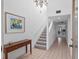 Bright entryway featuring tile flooring, stairs, and a wooden console table with artwork, welcoming guests into the home at 1621 Ne 2Nd St # 601, Ocala, FL 34470