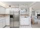 Kitchen featuring stainless steel refrigerator, white cabinetry, a sink and a view to the living room at 1621 Ne 2Nd St # 601, Ocala, FL 34470