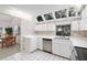 Well-lit kitchen with white cabinetry, stainless steel dishwasher, and tile floor, adjoined to dining area at 1621 Ne 2Nd St # 601, Ocala, FL 34470
