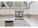 Bright kitchen featuring white cabinets, stainless steel dishwasher and a view of the outdoor landscape at 1621 Ne 2Nd St # 601, Ocala, FL 34470
