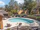 Community pool surrounded by lounge chairs and lush landscaping at 1621 Ne 2Nd St # 601, Ocala, FL 34470