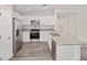 Spacious kitchen with white cabinets, granite countertops, stainless steel appliances and grey wood floors at 22 Juniper Drive Crse, Ocala, FL 34480