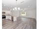 Open concept living room with grey wood floors, white kitchen, and dining room at 22 Juniper Drive Crse, Ocala, FL 34480