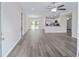 Open concept living room with gray wood-look floors and a kitchen with white cabinets at 22 Juniper Drive Crse, Ocala, FL 34480
