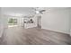Open concept living room with gray wood-look floors and a kitchen with white cabinets at 22 Juniper Drive Crse, Ocala, FL 34480