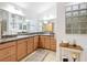 Elegant bathroom featuring dual sinks, wood cabinets, and a decorative glass block window at 383 Harlow Ln, The Villages, FL 32163