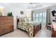 Bedroom with a queen bed, tiled floor, and a tray ceiling with a fan at 383 Harlow Ln, The Villages, FL 32163