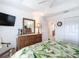 Bedroom with a king bed, wood dresser with mirror and ensuite bathroom at 383 Harlow Ln, The Villages, FL 32163