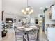 Charming dining area with wrought iron chairs, a glass table, and an elegant chandelier at 383 Harlow Ln, The Villages, FL 32163